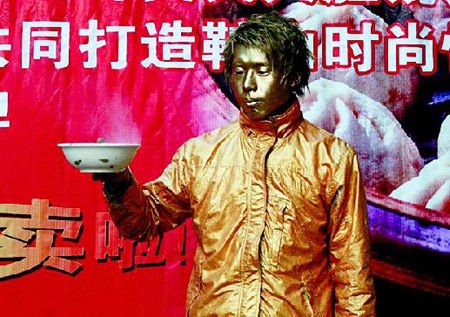 男子全身涂金漆扮雕塑 突然摆手吓坏路人(图)