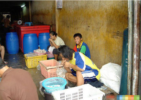 网友曝光黑作坊工人用嘴为凤爪剔骨(图)