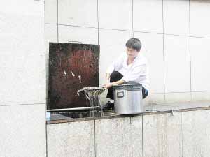 “小肥羊”厨师打捞地沟油 餐馆称分油渣免堵塞