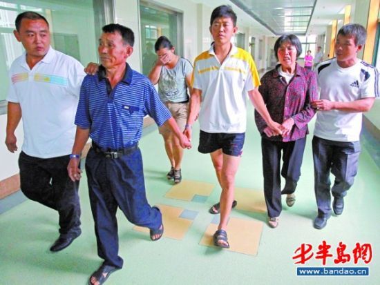 31日上午8时 40分许，田奎一家人手牵手送田典平(左二)进手术室。