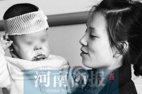 一岁半的小雨馨依偎在母亲的怀抱，和23岁的母亲相比，她的面容异常苍老