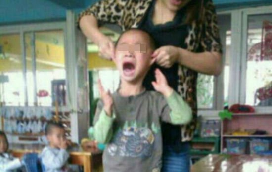 网上流传的颜艳红揪着男孩耳朵的照片。