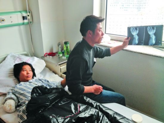 昨日，刘海云躺在病床上，丈夫王全校拿着她的断臂X光片心疼不已。