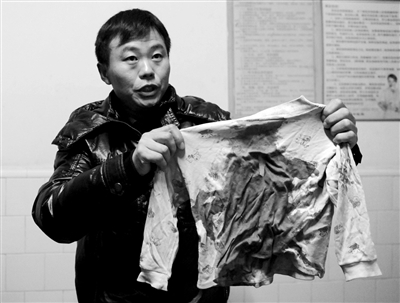 12月14日,受伤学生张萌的家人展示张萌当时所穿的衣服。