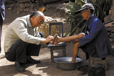 2012年11月20日，山石屏疗养院。李桂科医生为麻风病康复者修脚。李桂科是这里的全科大夫