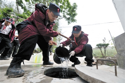昨日，北京市传染病防控卫生应急队工作人员为芦山县金花社区的水井消毒