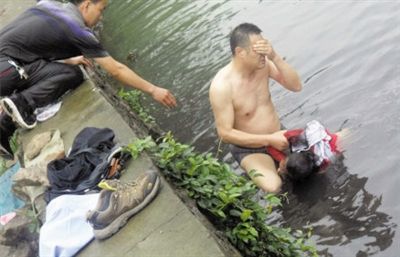 网友贴出民警张光聪一出河水就睁不开眼，用手抹去脸上脏水的照片