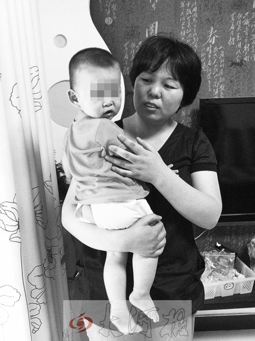 童童被妈妈抱在怀里。