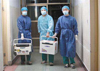 2012年8月16日凌晨，河南栾川县人民医院，医务人员提着装有捐献者胡小现器官的冷藏箱走出手术室