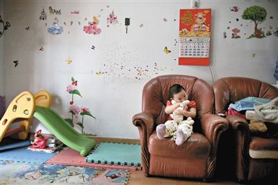 6月14日,未婚妈妈于军的家里。女儿悦悦抱着兔子玩偶,在听妈妈手机上的儿歌,这个4岁女孩喜欢兔子