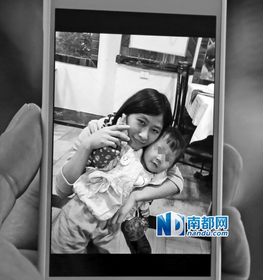 <p> 家人出示黄燕秋生前的照片,照片里她抱着亲戚家的孩子,面容清秀,笑容甜美。 南都记者 邹卫 摄</p>