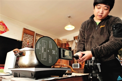 3月31日，实验人员在测试电磁炉磁感应值。新京报记者 秦斌 摄