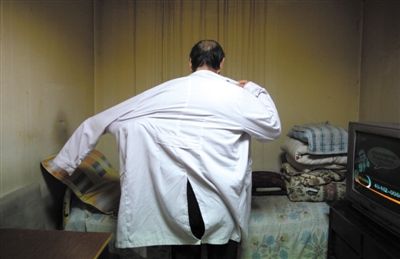 4月3日，朝阳区雅宝路附近一间地下室里，65岁的老陈换上白大褂要去“接孩子”。新京报记者 薛珺 摄